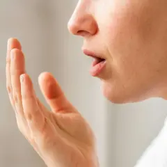 När en person känner efter dålig andedräkt, som kan bero på svamp i munnen (candidiasis cancer).