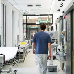 Sjukvårdare går längs en sjukhuskorridor med bårar. Kampen mot infektioner som candida auris kräver vaksamhet.