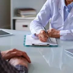 Läkare skriver ner patientens upplevelser av immunterapi biverkningar.