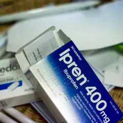 Ipren och Alvedon, två vanliga antiinflammatoriska mediciner, ligger i en korg med papper och pennor.
