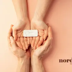 Två händer håller ett graviditetstest. Om du upplever klamydia symtom kvinna, kan ett snabbtest ge svar.