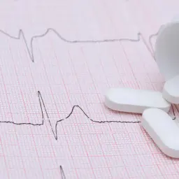 Vita tabletter, som kan vara beta blockerare, ligger utspridda på ett EKG-papper.