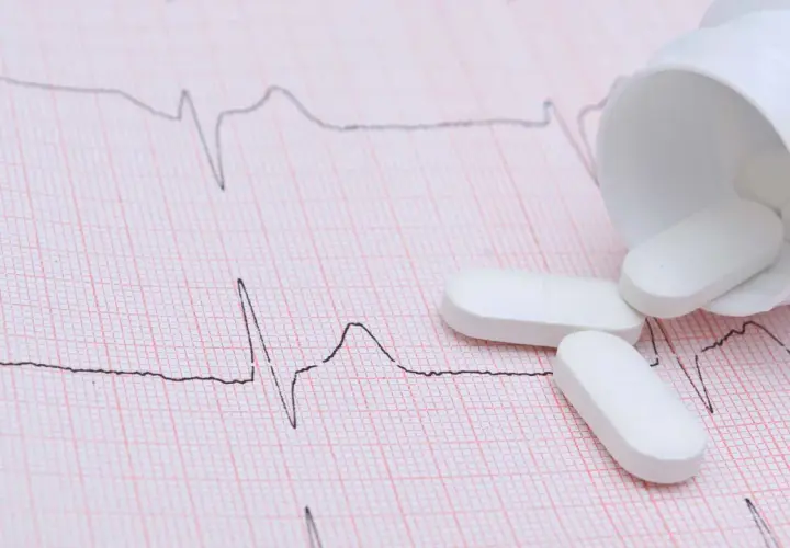 Vita tabletter, som kan vara beta blockerare, ligger utspridda på ett EKG-papper.