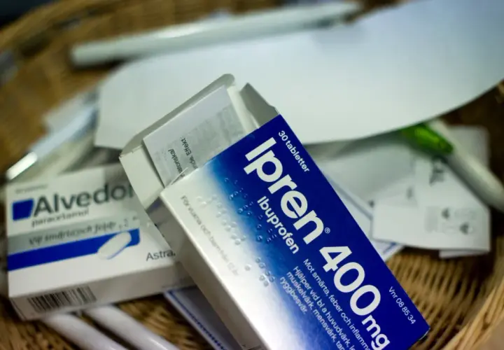 Ipren och Alvedon, två vanliga antiinflammatoriska mediciner, ligger i en korg med papper och pennor.