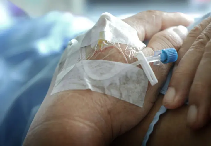 När morfin ges kan biverkningar uppstå. En hand med dropp och bandage syns, en påminnelse om medicinsk behandling.