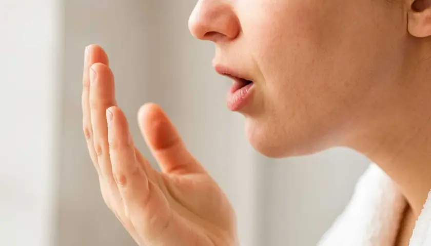 När en person känner efter dålig andedräkt, som kan bero på svamp i munnen (candidiasis cancer).