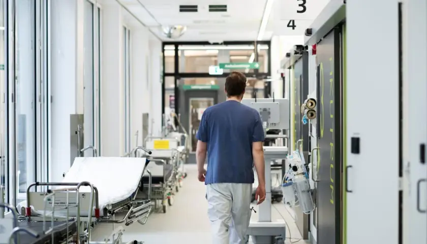 Sjukvårdare går längs en sjukhuskorridor med bårar. Kampen mot infektioner som candida auris kräver vaksamhet.