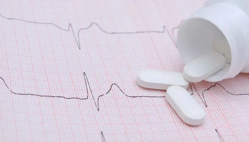 Vita tabletter, som kan vara beta blockerare, ligger utspridda på ett EKG-papper.
