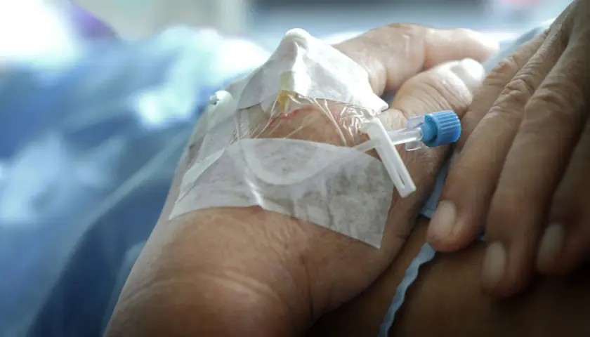 När morfin ges kan biverkningar uppstå. En hand med dropp och bandage syns, en påminnelse om medicinsk behandling.