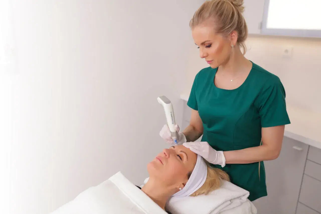 En hudterapeut använder Dermapen4 för att behandla en kvinnas ansikte.