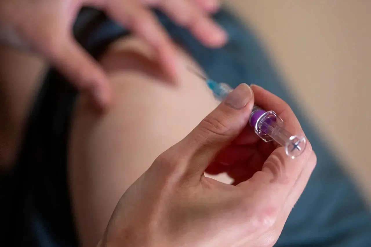 En spruta med vaccin förbereds för att skydda mot k virus.