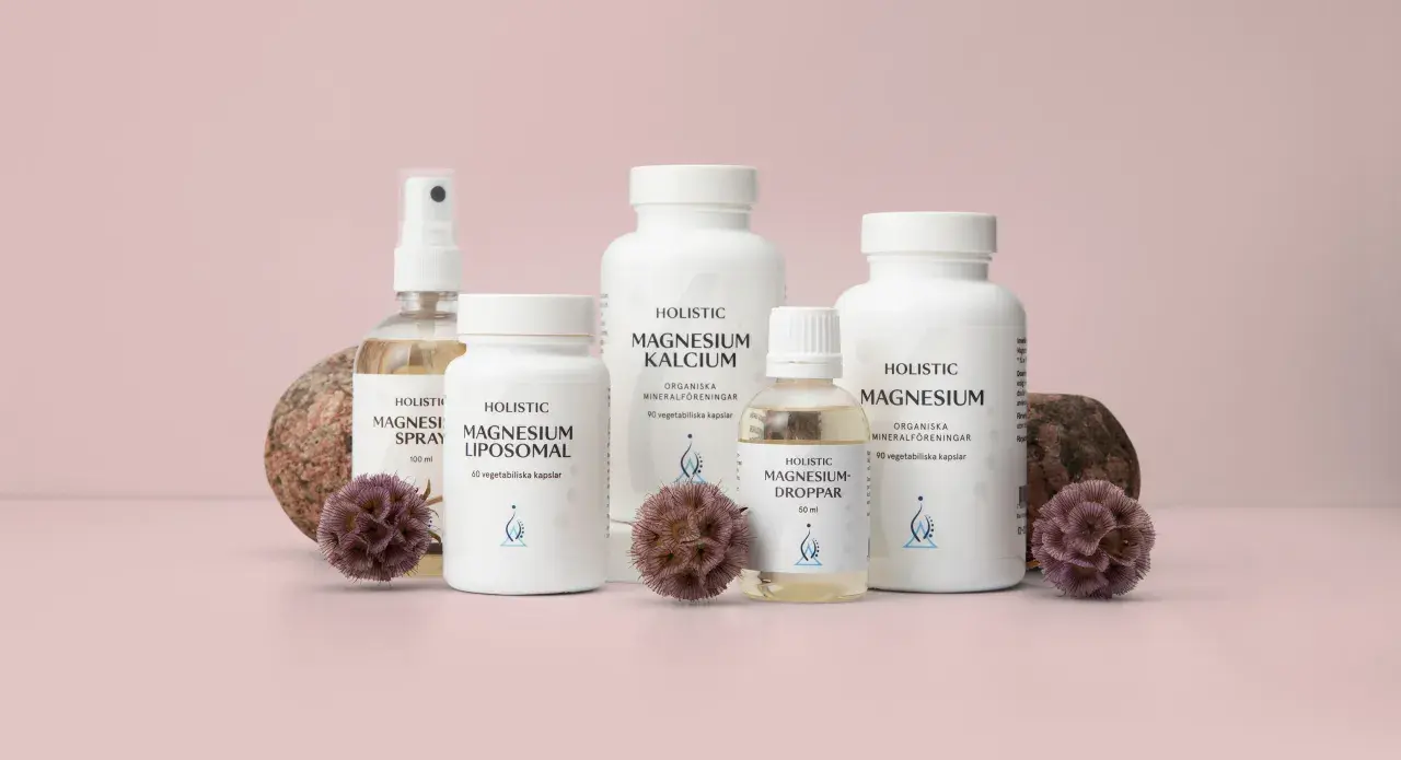 Holistisk medicin: flaskor med magnesiumprodukter, spray, kapslar och droppar, omgivna av stenar och torkade blommor.