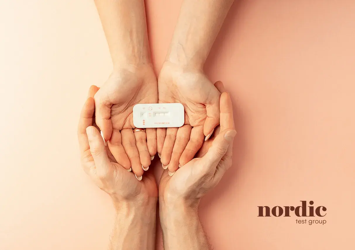 Två händer håller ett graviditetstest. Om du upplever klamydia symtom kvinna, kan ett snabbtest ge svar.