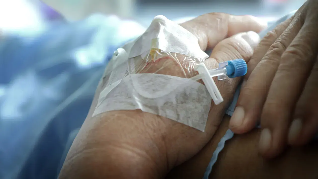 När morfin ges kan biverkningar uppstå. En hand med dropp och bandage syns, en påminnelse om medicinsk behandling.